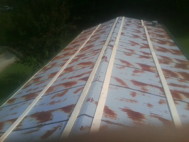 Rusted metal roof panels with new wood purlins before replacement — Storm Damage Roof Repair in Cressona by Roofing Brothers