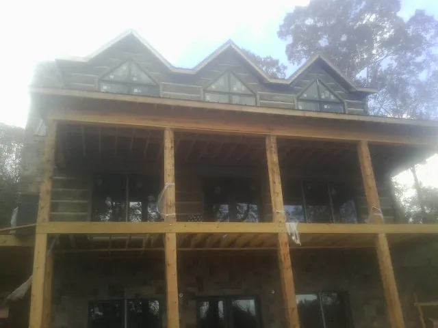 Dormers and porch framing on a large log home under construction — Roof Coating work by our crew in Cressona
